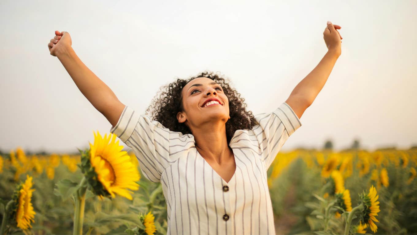 5 Reassuring Signs You’re Finally Getting Out Of Living In Survival Mode Woman standing in sunflower field
