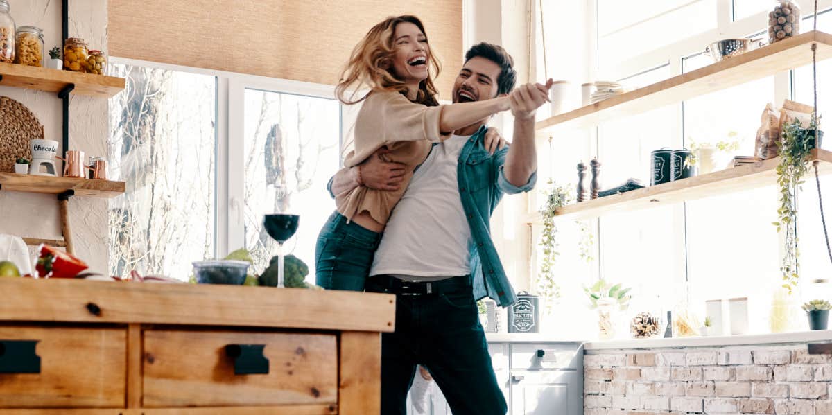 The Hard Truth About Living With ADHD As A Couple silly couple dancing in their kitchen