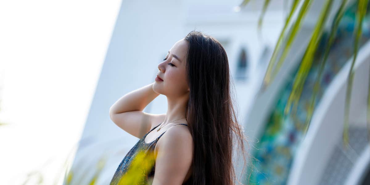 11 Signs You Have Emotional Trauma From A Broken Heart woman surrounded by palm leaves