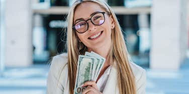 rich woman holding a wad of cash